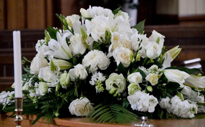 White funeral flowers, including roses and lilies